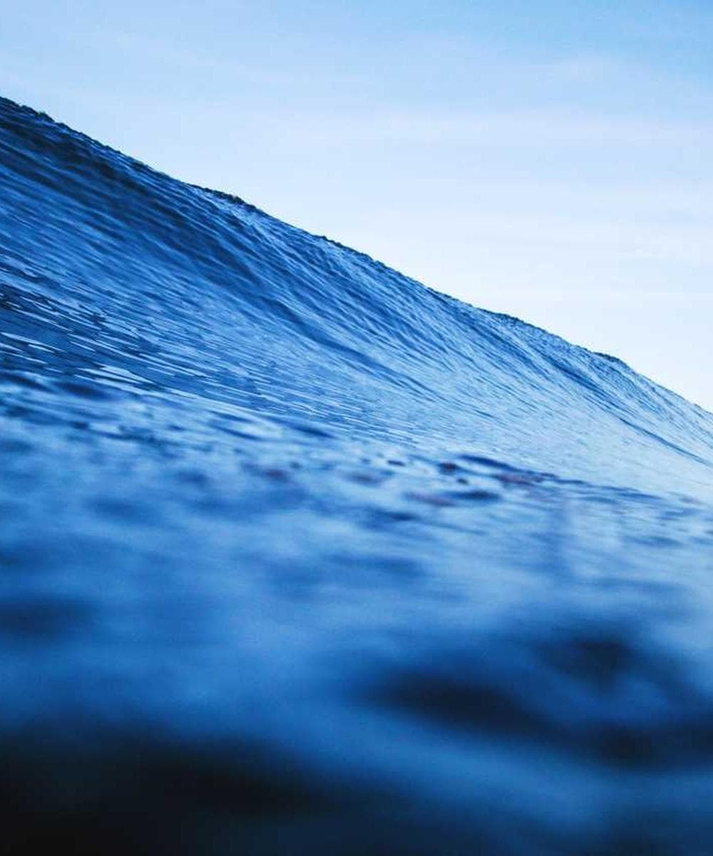 A close-up of a luxurious gold watch on a white marble background